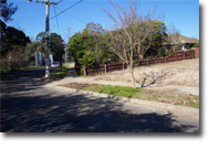 Photo of a streetscape and access to a block of land.