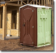 Photo of temporary toilet in front of a house under construction.