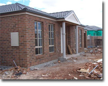 Photo of a brick house under construction.