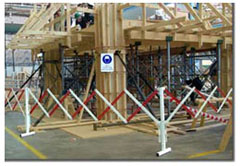 Photo of a timber frame of a commercial construction. There are safety barriers around the perimeter of the building.