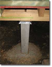 Photo of a concrete stump supporting a bearer and joists. There is ant capping on the stump. 