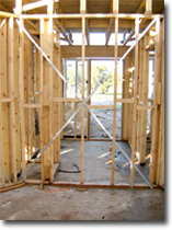 Photo of a metal straps bracing the frame of a house under construction.
