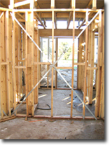Photo of a metal strap bracing part of the frame of a house under construction.