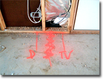 Photo showing red markings on the floor below a frame.