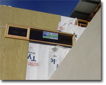 Photo of a building under construction with some cladding installed.